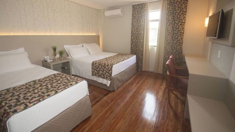 Recharge in a bright room with desk and restful beds.