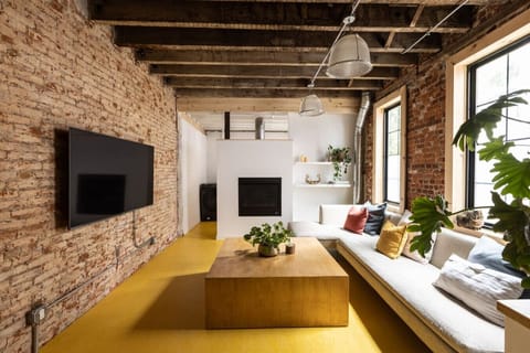 First floor open plan layout has a beautiful living room with gas fireplace and large flat screen TV. Just behind the white partition wall is the laundry and half bath.