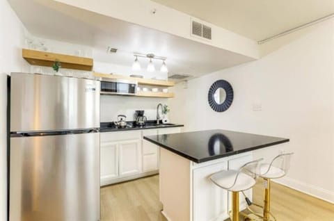 Updated kitchen with island seating, stainless appliances, and open shelves
