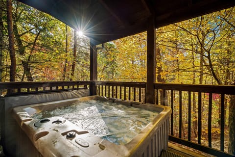 The perfect outdoor retreat with comfortable seating, a bubbling hot tub, and breathtaking forest views.