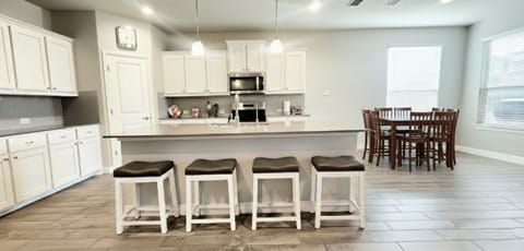 Full open kitchen with 4 bar stools for breakfast area and a large island