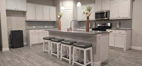 Full open kitchen with 4 bar stools for breakfast area and a large island