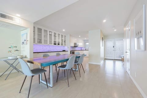 Gather around the unique, modern dining table with comfortable seating for six. Perfect for memorable meals with a view of the stylish, fully-equipped kitchen area.