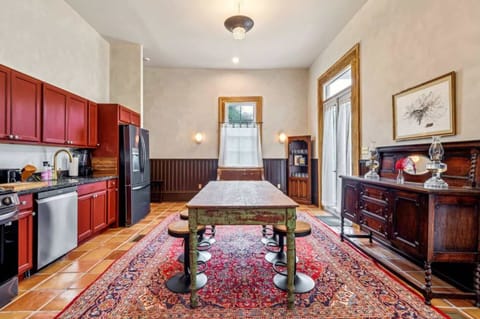 Open kitchen with bold cabinetry and an antique-style farmhouse table.