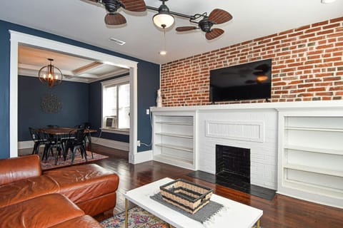 Living Room: Stylish retreat with brick accents, inviting leather sofa, and vibrant decor!