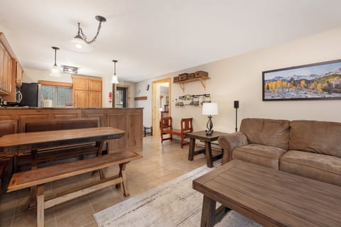 Relax in your spacious living area with rustic wood furnishings and mountain art, perfect for unwinding after your adventures.