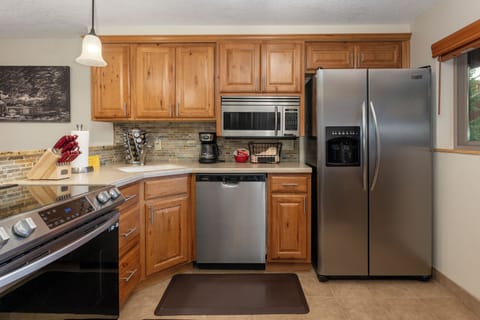 Your fully equipped kitchen invites culinary adventures with warm wood cabinets, granite counters, and stainless steel appliances ready for your favorite meals.