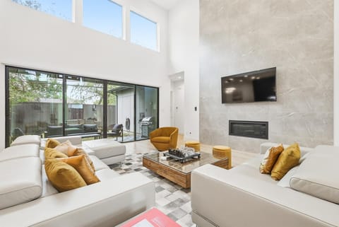 This living room looks like it waltzed off the cover of the latest Architectural Digest with lofty high ceilings, a spacious open-concept layout, and modern, luxury furniture!