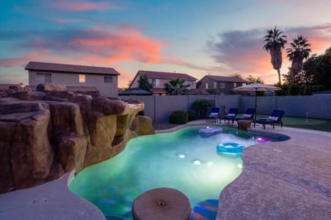 Approximately 350 square feet, this play pool features colorful lighting, pool floats, and lounge seating beneath the Arizona sunset.