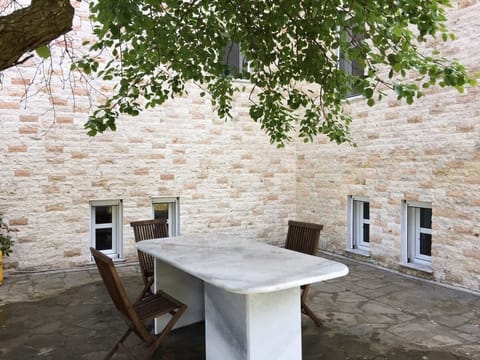 Authentic Mediterranean charm with stone walls and shaded outdoor dining — perfect for evening meals.