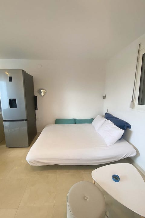 Simple and serene bedroom filled with natural light and fresh sea air for restful sleep.