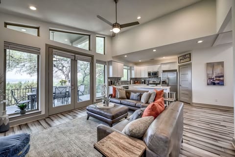 Bright open living room with soaring ceilings and lake views beyond.