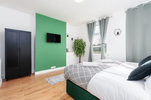 Spacious master bedroom with super king zip-link bed (2x single beds), TV and a fresh modern style.