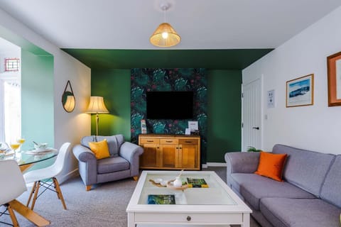 Bright and cosy living room with a stylish feature wall, perfect for relaxing after a day exploring Buxton.