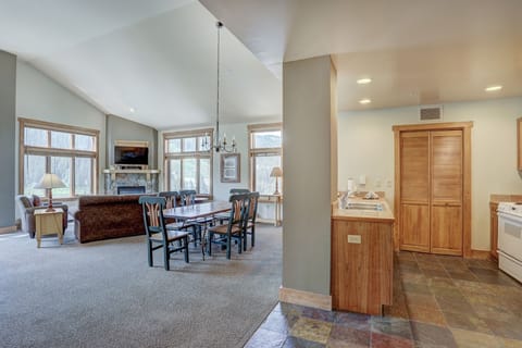 Sunlight pours through floor-to-ceiling windows in the open-plan dining and kitchen area.