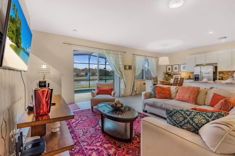 Enjoy a cozy living area with a vibrant red rug and plush seating, ideal for unwinding after your adventures. A large window lets in natural light, enhancing the warm decor and offering a lovely view outside.