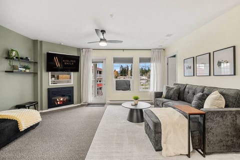 Living room with a gas-lit fireplace, smart TV, board games, walkout access to the balcony and a luxurious couch with a sleeper sofa (all bedding provided.)