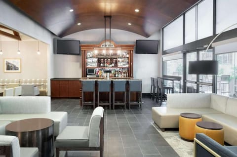 Bar area with counter seating, sofas, and large windows