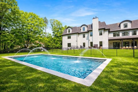 Private yard with fenced pool, playful water jets, and spacious patio dining.