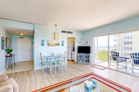 Spacious open living area with sliding glass doors that lead to private  balcony