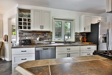 Modern kitchen with stone backsplash and built-in wine storage. Everything you need to host a memorable dinner.