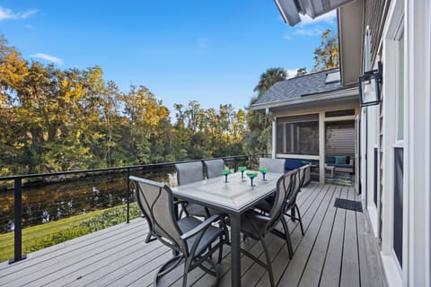 Step outside to the expansive deck overlooking the peaceful lagoon—ideal for outdoor dining or morning coffee surrounded by lush palms and moss-draped oaks