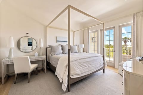 Drift into luxury beneath a canopy bed and balcony doors.