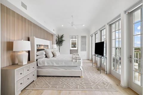 Unwind in a sunlit primary suite with serene balcony views.