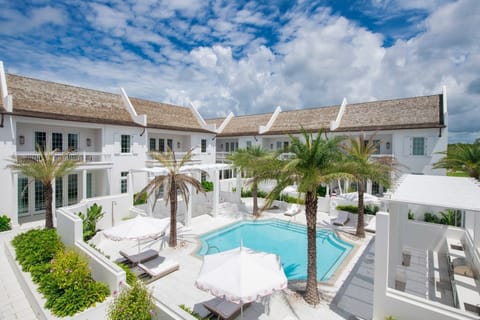 Unwind poolside under swaying palms in serene sunshine.