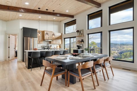 Modern kitchen and dining area with sleek finishes and expansive windows overlooking the Smoky Mountains.