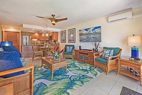 Enjoy an open-concept living space with comfortable seating, colorful accents, and easy access to the kitchen.