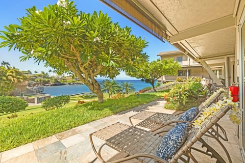 Relax on a private lanai with comfortable seating and lush greenery, overlooking breathtaking ocean views.