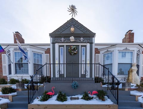Historic brick exterior with charming entryway and seasonal wreath welcoming guests