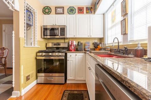 stainless-steel kitchen equipped with gas range, microwave, and fully stocked cabinetry