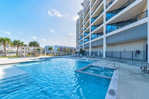 Sparkling pool and hot tub await your relaxation under sunny skies, with comfortable loungers for soaking up the Florida sunshine.