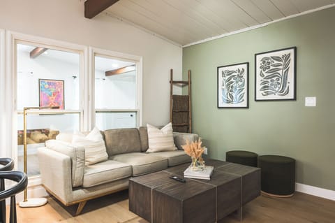 living room have huge glass panels & pop of greens 