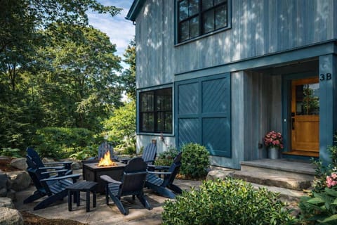 Coastal modern home with Adirondack seating and lush landscaping