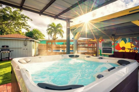 Unwind in your private backyard oasis featuring a hot tub under a covered patio. Playful mural vibes set the scene—perfect for evening soaks, sunny lounging, and unforgettable moments of relaxation.