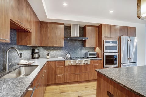 Bright chef’s kitchen with granite countertops, stainless-steel range, and double ovens.
