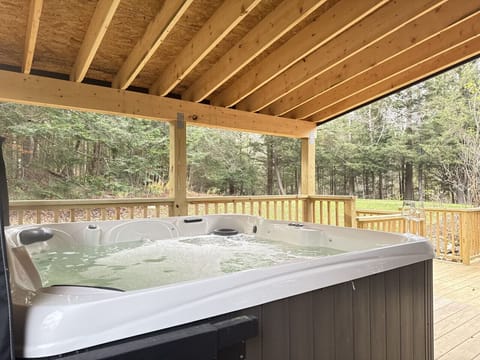Relaxing hot tub outside under a roof.