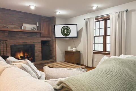 Bright living room featuring a fireplace and comfy seating with a TV.