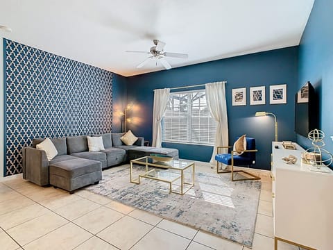 Bright living room with stylish blue accent walls and cozy sectional seating.