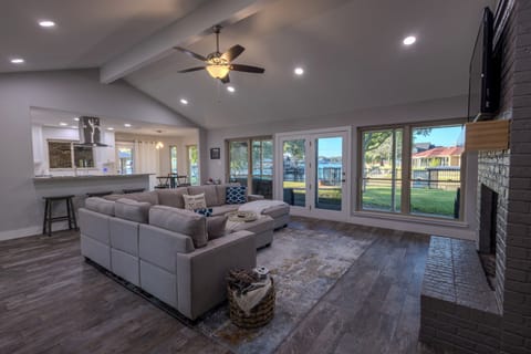 Spacious, open living room with 180 degrees lake and property views, glass doors