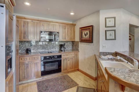 Fully equipped kitchen with natural wood cabinetry and stone countertops for effortless mountain dining.