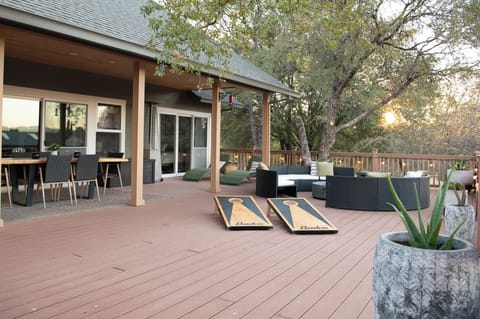 Spacious outdoor deck with sun loungers, dining table, fire pit & BBQ grill.