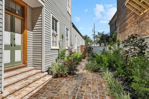 Private brick walkway leading to the backyard, and surrounded by lush landscaping and classic New Orleans charm.