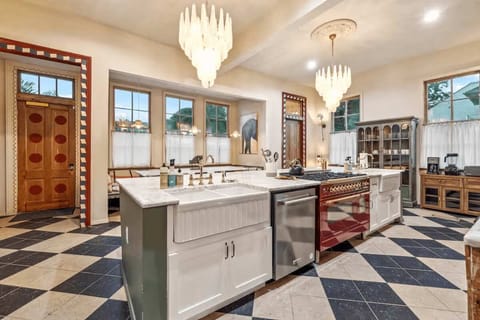 Chef’s kitchen with large island, luxury range, and checkerboard flooring.