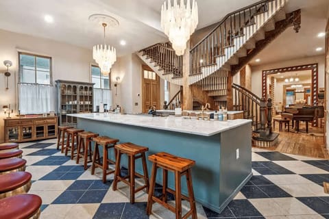 Open kitchen with large island, statement chandeliers, and bar seating.