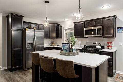 Modern kitchen w/ large island, stainless appliances & plenty of prep space.