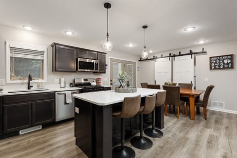 Open-concept layout connects kitchen, island seating & dining for easy hosting.